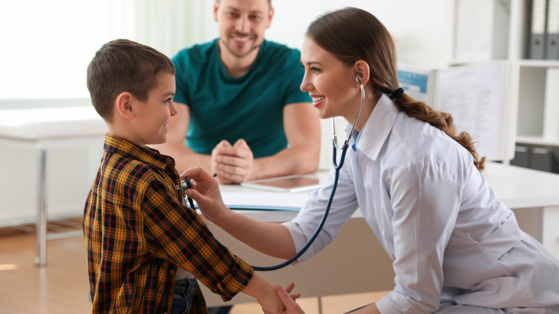 Doctor less. Doctor examining boy with stethoscope. Doctor examines a little. Doctor examining a teenage boy with a stethoscope stock phot. Father son Doctor's visit.