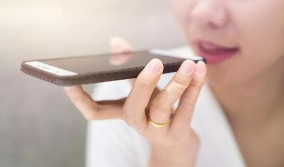 Close-up of female doctor dictating into mobile phone.