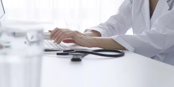 physician typing on computer