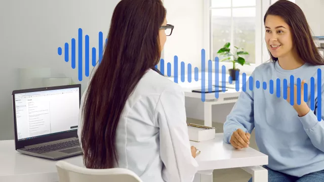 a doctor and a woman in a medical office talking with a computer recording the conversation