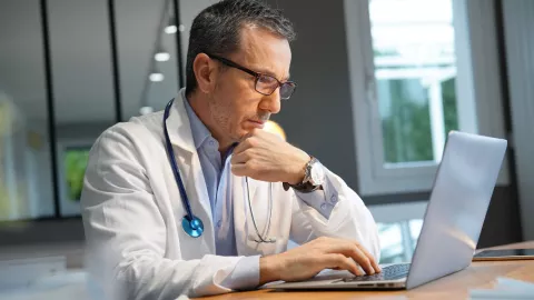 Doctor comparing EHRs